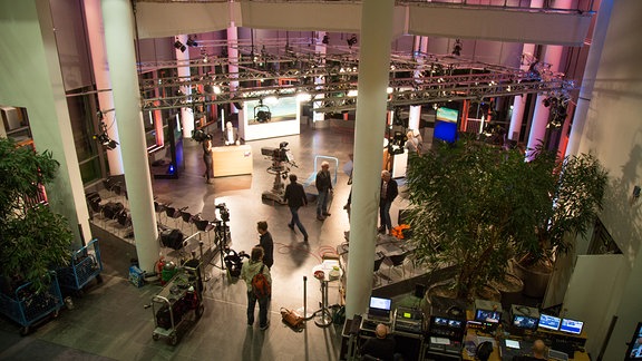 Das Foyer des MDR Landesfunkhauses in Erfurt. In dem großen Raum stehen Kulissen, Kameras und Möbel. Mehrere Menschen laufen in dem Raum herum.