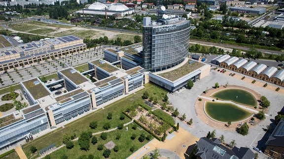 Luftaufnahme von 2013 vom größten Teil des Geländes der MDR-Zentrale in Leipzig unter anderem mit Hochhaus und Feuerlöschteich. Nebenan ist die Mediacity zu sehen. Im Hintergrund Hallen der Alten Messe.