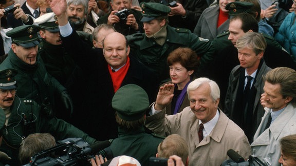 Bundespraesident Richard v. Weizsaecker und der regierende Buergermeister Walter Momper mit Polizisten und Presse in der Menschenmasse am Grenzübergang Potsdamer Platz. Berlin, 12.11.1989