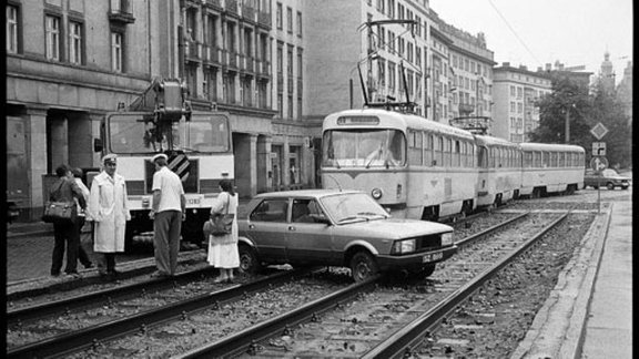 Auto steht auf Straßenbahnschienen, deswegen kann die Straßenbahn nicht weiter fahren.