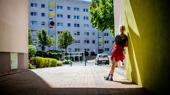 Ein Kind steht vor einem Plattenbau in Leipzig-Grünau (2020)