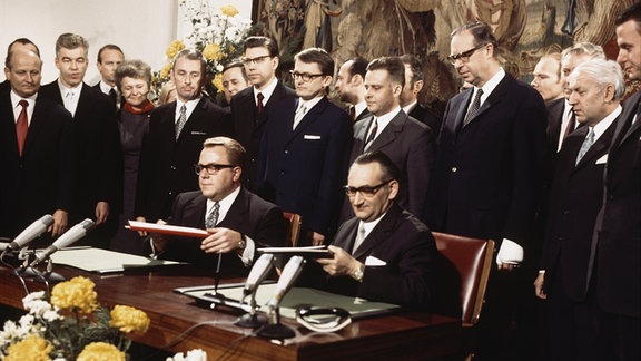 Im Gobelin-Saal im Palais Schaumburg in Bonn wurde das Berlin-Transit-Abkommen durch Staatssekretär Egon Bahr vom Bundeskanzleramt (rechts) und Staatssekretär Michael Kohl vom DDR-Ministerrat (links) unterzeichnet. Das erste Regierungsabkommen zwischen beiden deutschen Staaten gibt zum ersten Mal seit Ende des II. Weltkrieges dem Berlin-Verkehr zu Lande und zu Wasser eine rechtlich fixierte Grundlage. (Die anderen abgebildeten Personen sind nicht identifiziert). 