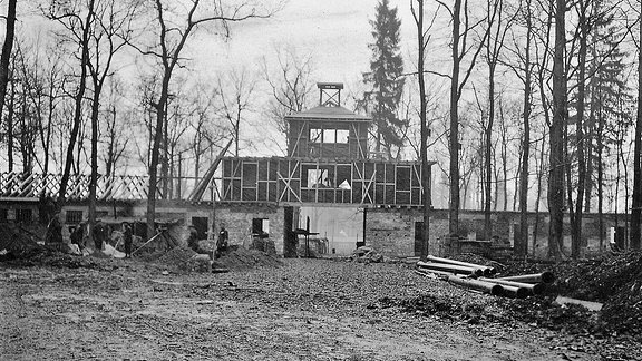 Im November 1937 ist das später bekannt gewordene Torgebäude im Rohbau fertig. Die Häftlinge müssen oft 14-16 Stunden am Tag schuften.