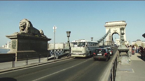 Ein alter Bus fährt über eine Brücke