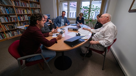 Menschen sitzen an einem Tisch 