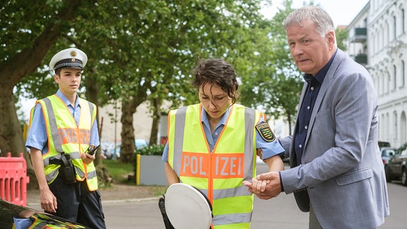 Ein Mann hält die Hand einer Polizistin