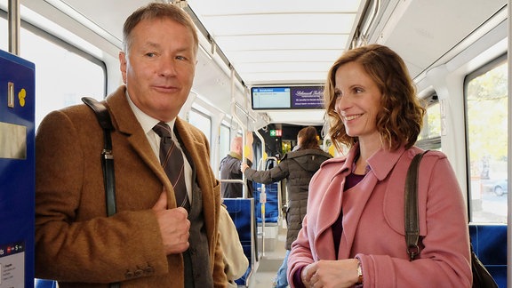 Roland Heilmann (Thomas Rühmann) fährt mit der Straßenbahn und spricht mit einer Frau (Julia Jäger).