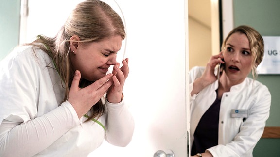 Dr. Julia Berger (Mirka Pigulla, re.) vom Johannes-Thal Klinikum in Erfurt ist im Rahmen eines Belegarztprogrammes in der Leipziger Sachsenklinik. Sie hat sich ein wenig verlaufen und als sie die richtige Tür findet, erwischt sie mit vollem Schwung Schwester Miriam (Christina Petersen, li.).