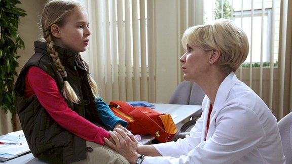 Lisa (Ella Zirzow, li.) vermisst ihren Vater so sehr, dass sie Roland Heilmann in der Sachsenklinik besuchen möchte. Dr. Kathrin Globisch (Andrea Kathrin Loewig, re.) tröstet sie, denn Lisas Vater ist heute zu einem Vortrag nach Dresden gefahren.