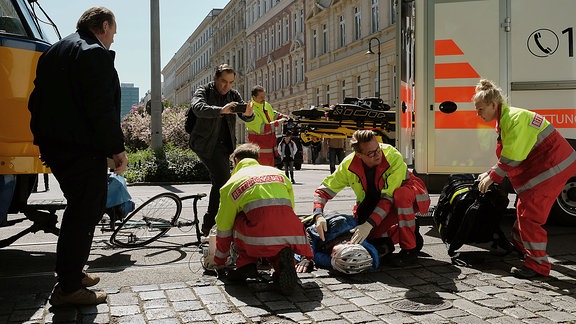 Rettungskräfte werden von einem Mann mit Handy gefilmt (Folgenszene)