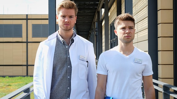 Florian und Kris laufen an der Klinik entlang.