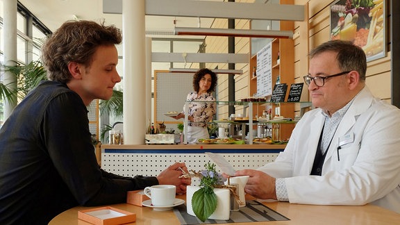 Daniel Gerdes (David Nolden, li.) redet in der Cafeteria mit Hans-Peter Brenner (Michael Trischan, re.).