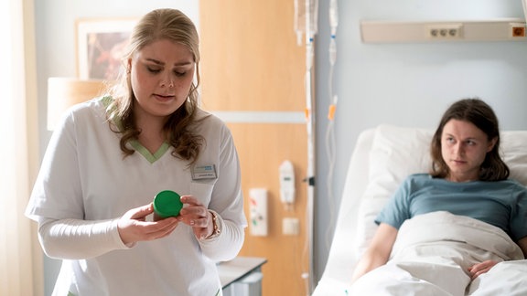 Schwester Miriam Schneider (Christina Petersen) soll von Felix Rückert (Tom Böttcher) eine Urinprobe holen. 