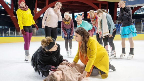 Nachwuchs-Eiskunstläuferin Solveig liegt bewusstlos auf dem Eis. Arzu Ritter und Mutter Jutta helfen.