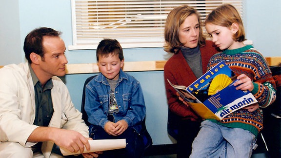 Familie Leipold (Dagmar Sitte, 2.v.r., Nadja Scheibe, rechts, Robin Issa) möchte seit Jahren endlich wieder zusammen ans Meer fahren. Doch der Vater mußte mit einer schweren Gallenkolik in die Sachsenklinik eingeliefert werden. Dr. Kreutzer (Johannes Steck, links) kümmert sich um den Patienten und um dessen Familie.