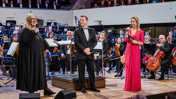 MDR-Programmdirektorin Jana Brandt, MDR-Intendant Ralf Ludwig und Moderatorin Sissy Metzschke auf der Bühne des Leipziger Gewandhauses beim Festkonzert zum 100. Geburtstag der MDR-Ensembles