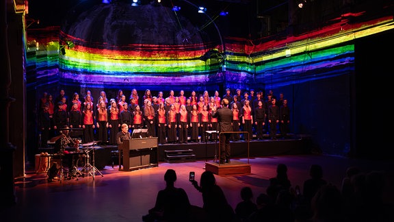 MDR-Kinderchor beim Konzert "Klanglabor" in der Schaubühne Lindenfels Leipzig, im Hintergrund bunte Projektionen auf der Wand