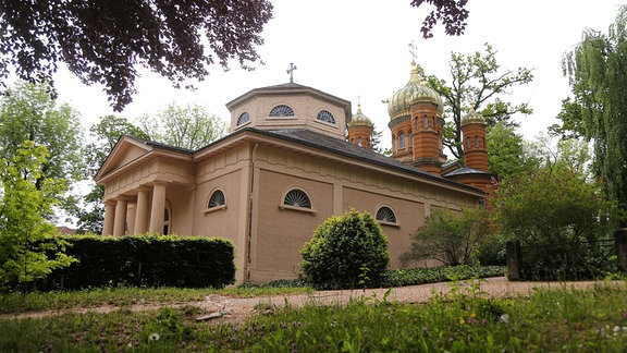 Fürstengruft auf dem alten Friedhof in Weimar, ein Gebäude mit Türmchen und roter Fassade, umgeben von Bäumen