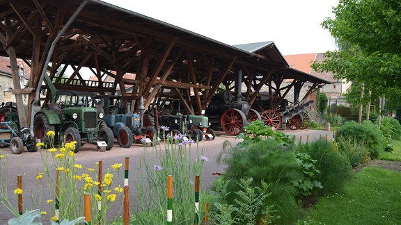 Mähdrescher, Traktoren stehen in einer Reihe unter dem Hofdach des Börde Museums Burg Ummendorf. 