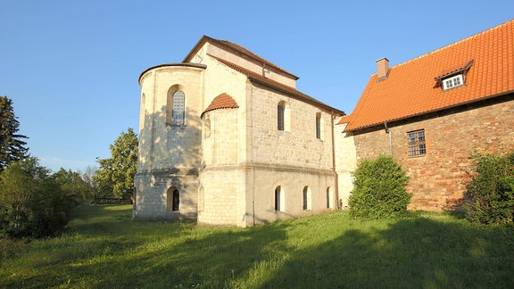 Ein Blick auf die romanische Konradsburg mit Basilika; sie wird von Sonnenschein angestrahlt und ist von grün umgeben