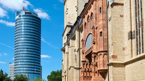 Außenansicht einer Kirche, im Hintergrund ein Hochhaus