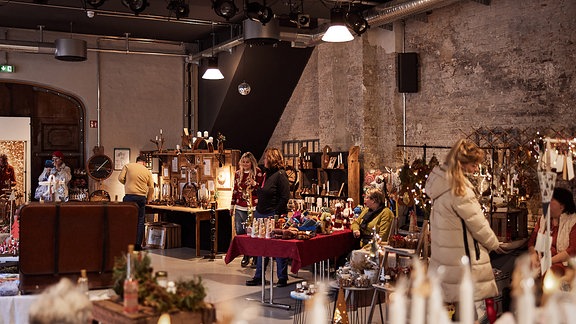 Ein Blick in eine Halle, darin ist ein Markt aufgebaut mit verschiedenen Ständen.