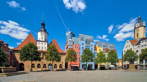 Jenas Marktplatz mit bunten Häusern, dem historischen Rathaus und im Hintergrund der Jentower.