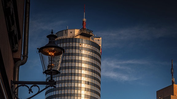 Hochhaus JenTower von der historischen Wagnergasse fotografiert. Im Vordergrund Altstadthäuser.