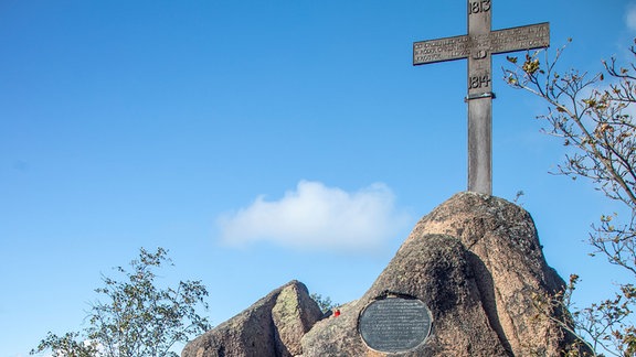 Blick auf ein eisernes Kreuz in einer felsigen Landschaft.