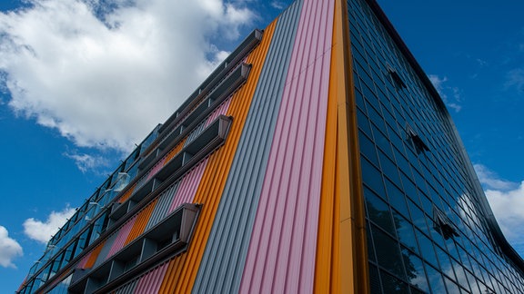 Blick von unten auf die Experimentelle Fabrik der Otto-von-Guericke Universität: Ein Kastenbau mit bunter Wellblech-Verkleidung.