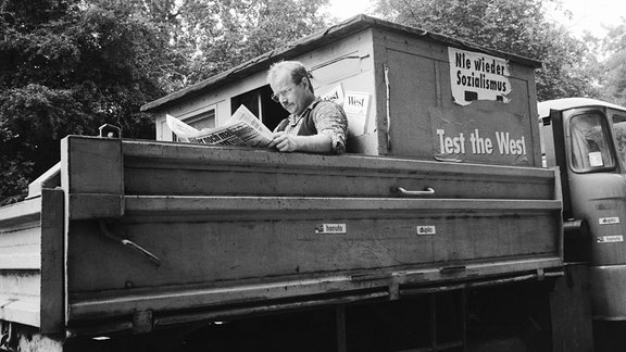 Ein Foto von Martin Jehnichen zeigt einen Barkas mit Aufklebern "Nie wieder Sozialismus" und "Test the West" 1990 (Dresden)