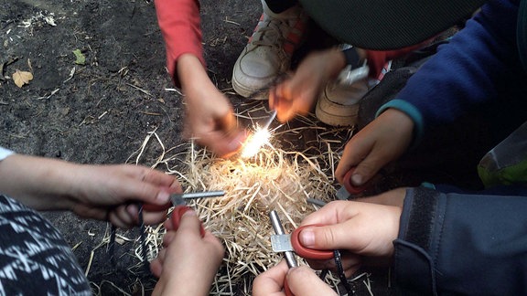 Kinder lernen wie man in der Steinzeit Feuer macht