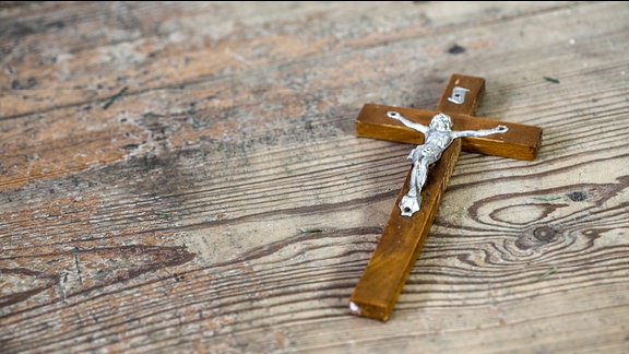 Ein Kreuz liegt auf einem Tisch.