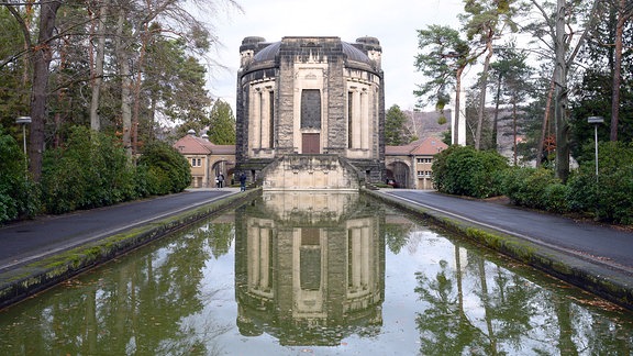 Das Krematorium Dresden-Tolkewitz spiegelt sich in einem Wasserbecken. 