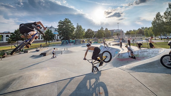 Menschen fahren in einem Skatepark.