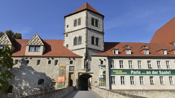 Die Moritzburg Halle von außen. Eine Brücke führt zum Torbogen, über dem ein Turm ist.