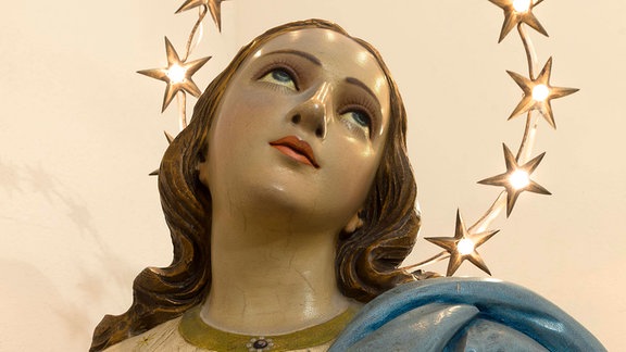 Hölzerne Büste der heiligen Maria mit Sternenkranz beleuchtet