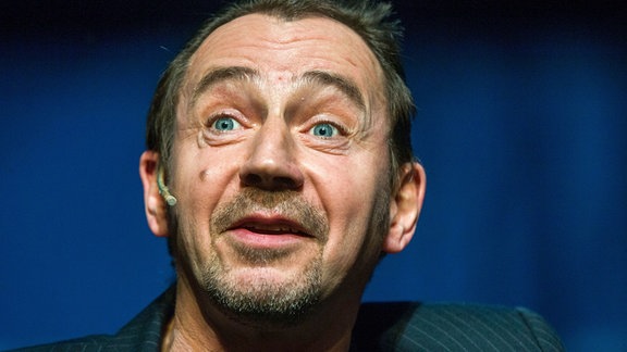 Der Schauspieler Thorsten Merten: ein Mann mit kurzem Haar blickt aufgeweckt