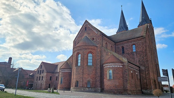 Außenansicht eines roten Backsteingebäudes vor blauem Himmel  