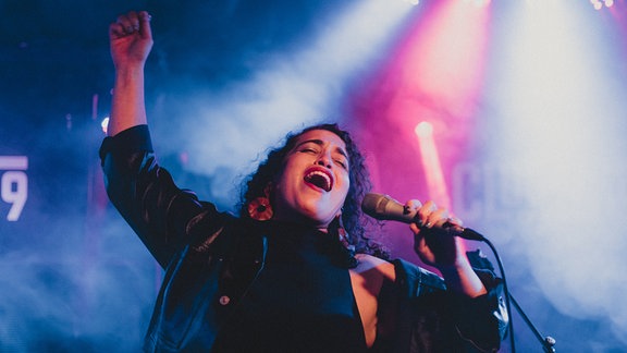 Die Musikerin Naama Guggenheim singt bei einem Auftritt ins Mikrophon.