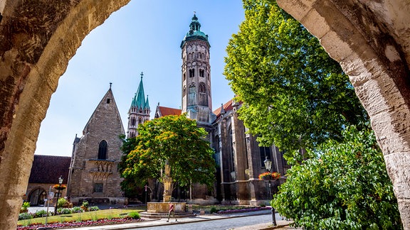 Blick durch einen Torbogen auf den Naumburger Dom bei Sonnenschein