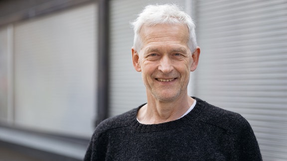 Andris Plucis, ein Mann mit grauen Haare lächelt.