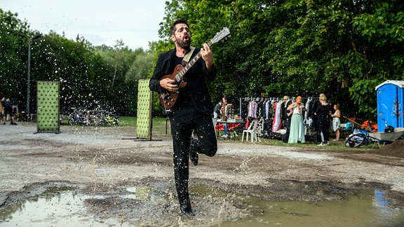 Sommertheater in Weimar: Nahuel Häflinger spielt Hamlet und spielt Gitarre in einer Pfütze tanzend