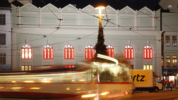 Steintor Varieté in Halle von außen, davor eine vorbeirasende Straßenbahn