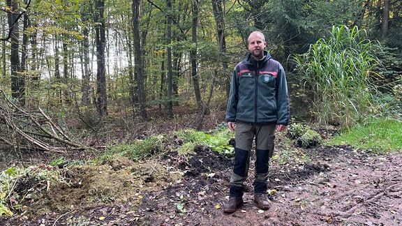 Förster Ronny Luc vom Revier Gehren steht vor einer illegalen Grünschnittdeponie im Wald.