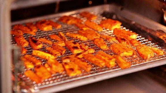 Pommes aus Süßkartoffeln auf einem Backblech mit Gitter