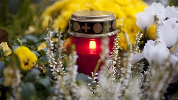 Brennendes Grablicht auf einem Friedhof