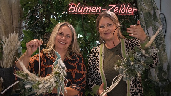 Diana Fritzsche-Grimmig und Claire Zeidler halten Herbstfloristik in den Händen.