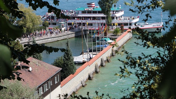 Steg im Bodensee mit Schiff und Booten.