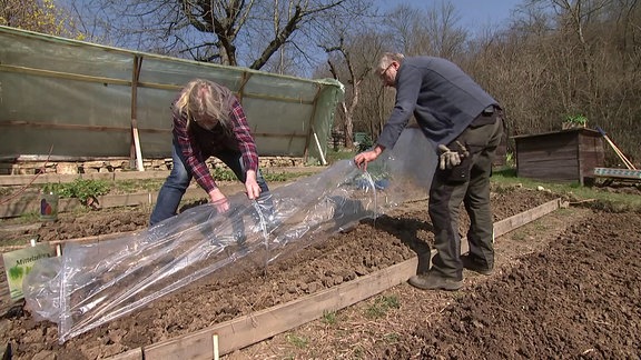 Zwei Männer arbeiten im Garten.